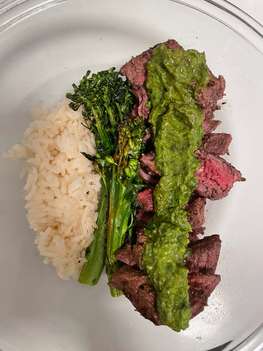 Bone broth white rice, oven roasted broccoli, and medium rare filet mignon drizzled with Besto on top.